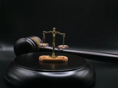 Balanza de la justicia y mazo de juez sobre fondo oscuro